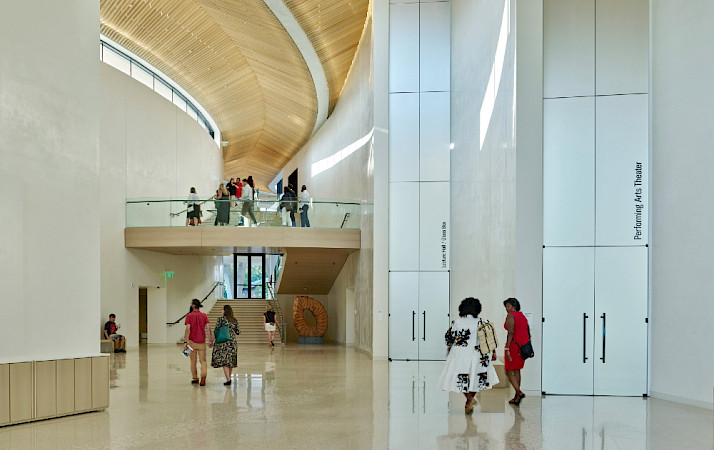 Photo of a people walking through the Atrium at the Arkansas Museum of Fine Arts.