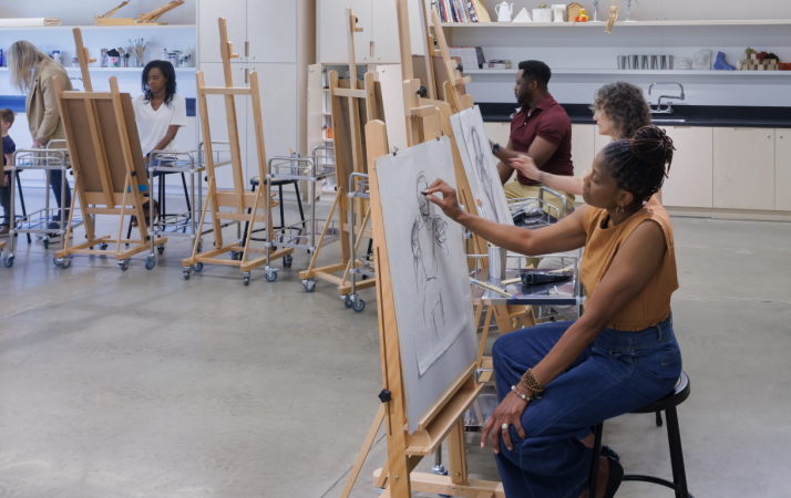 Photo of people drawing on easels in an art studio.