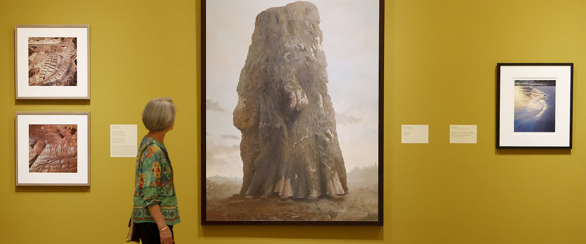 Photo of a woman looking at a large painting in an art gallery.