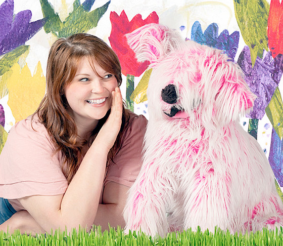 Photo of a pink puppet dog in front of a flowery background.