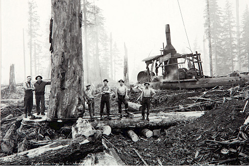 Black and white photograph of loggers in a forest by Darius Kinsey.