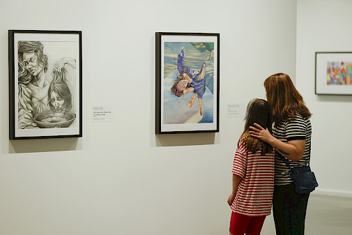 Photo of a mother and young daughter looking at art in an art gallery.