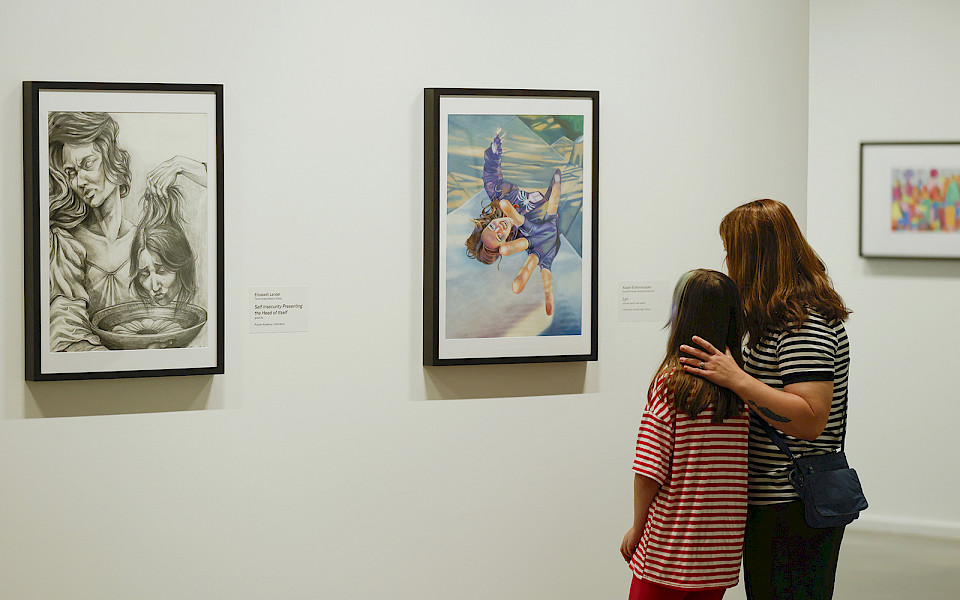 Photo of a mother and young daughter looking at art in an art gallery.