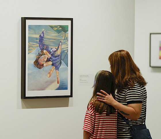 Photo of a mother and young daughter looking at art in an art gallery.