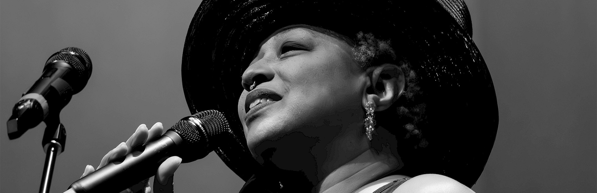 Black and white photo of Ms. Lisa Fischer singing into a microphone. Photo by Jeff Insel.