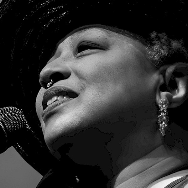 Black and white photo of Ms. Lisa Fischer singing into a microphone. Photo by Jeff Insel.