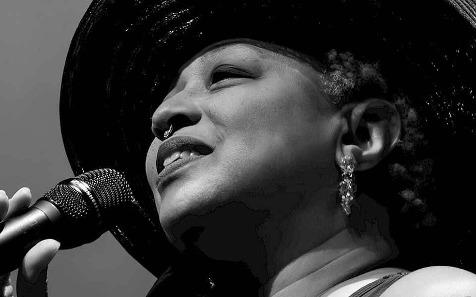 Black and white photo of Ms. Lisa Fischer singing into a microphone. Photo by Jeff Insel.
