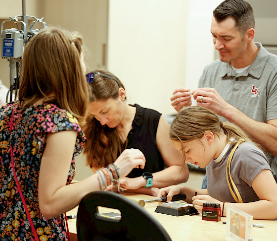 Photo of a family doing an art activity in an art studio at the Arkansas Museum of Fine Arts.