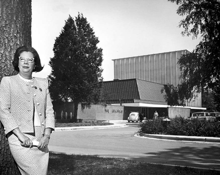 Black and white photo of Jeanette Rockefeller standing in front of the Arkansas Arts Center in the 1960s.