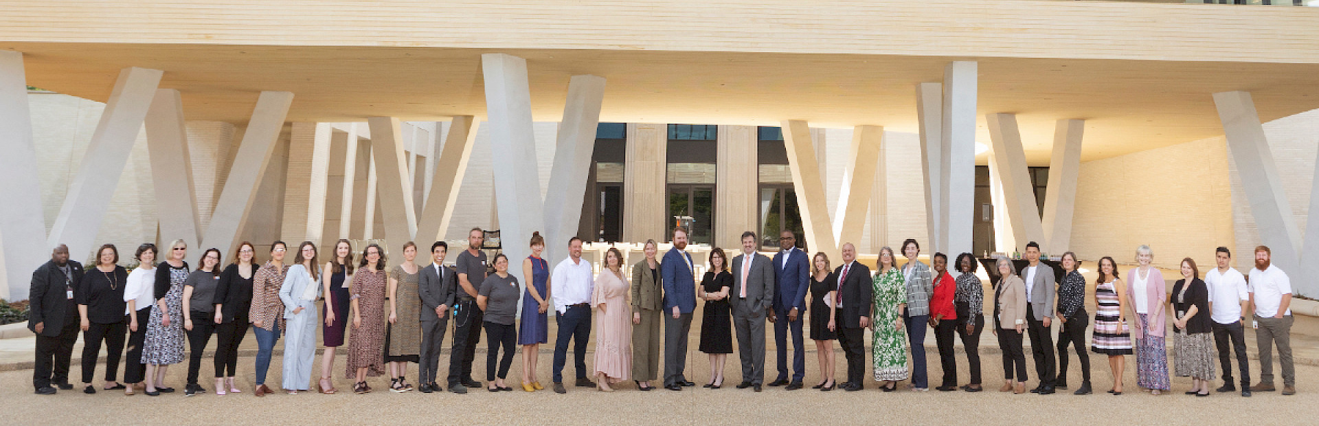 Photo of a large group of AMFA staff members standing in front of the North Entrance to the new Museum.