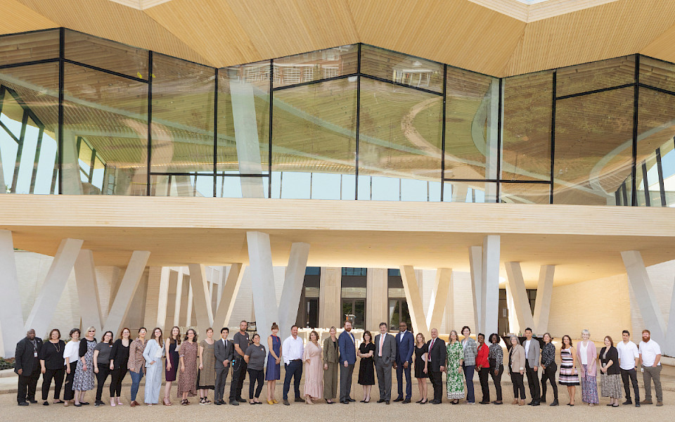 Photo of a large group of AMFA staff members standing in front of the North Entrance to the new Museum.