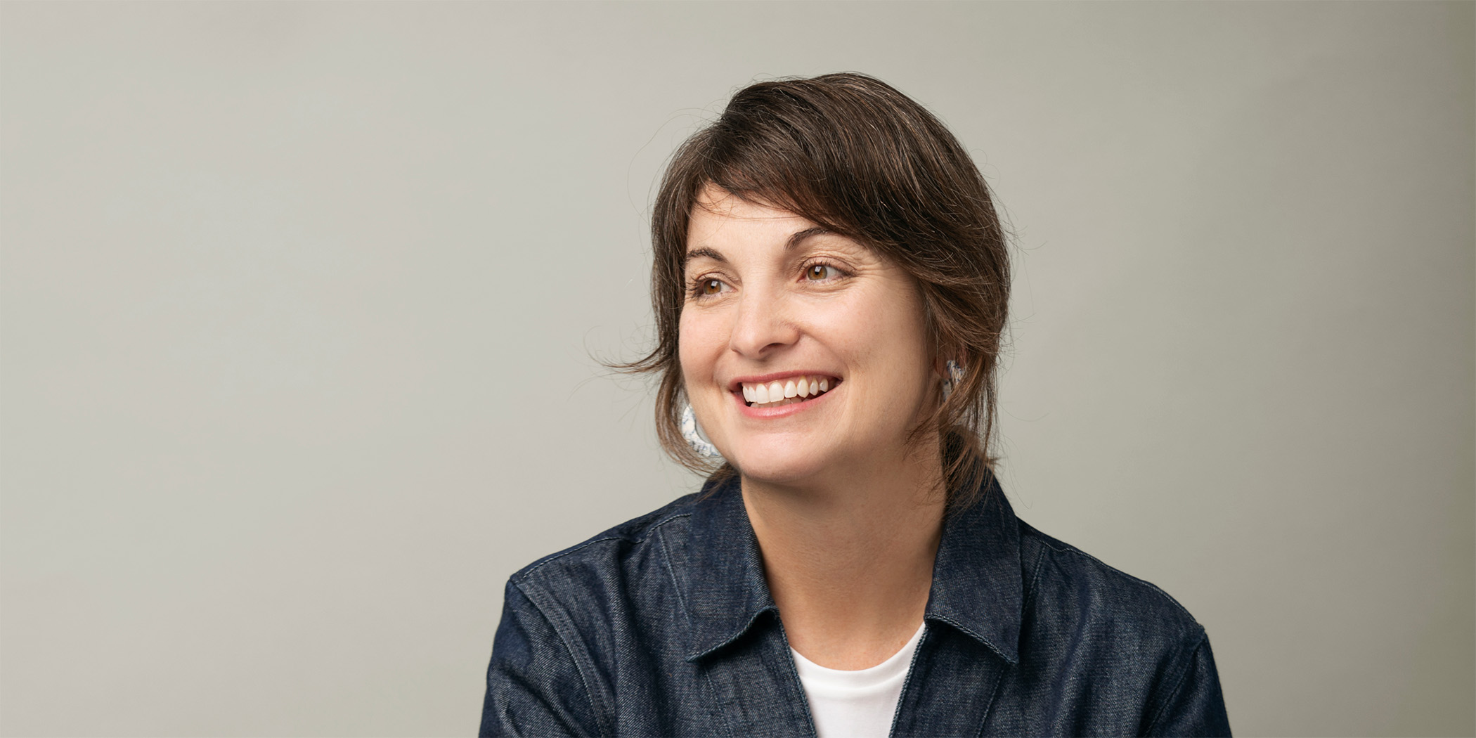 Photo of a woman smiling and wearing a white shirt and navy jacket.