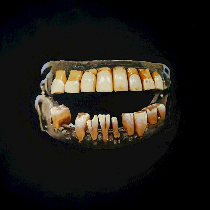Photo of a painting of false teeth on a black background.