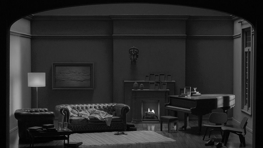 Film still depicting a small set decorated as a living room.