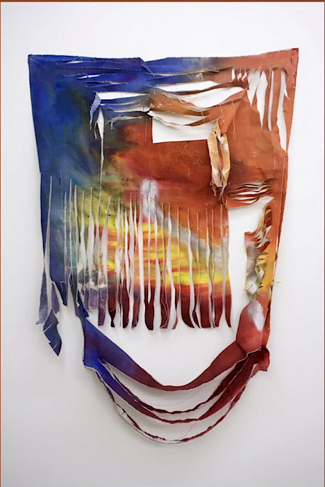 A rainbow-colored sheet of canvas torn in vertical and horizontal strips hanging on a white wall.