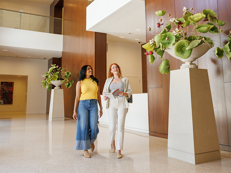 Photo of two young women walking in the 1937 Lobby at the Arkansas Museum of Fine Arts.