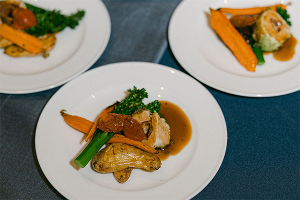 Photo of three plates containing vegetables and a sauce.