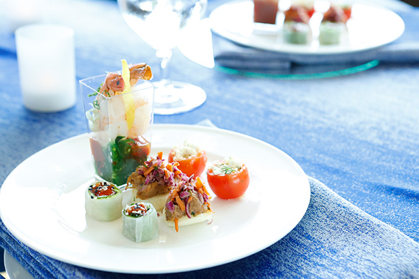 Photo of a white plate containing miniature tasting bites of food.