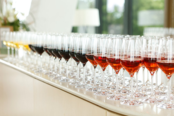 Photo of a bar holding dozens of glasses of red, rosé, and white wine.