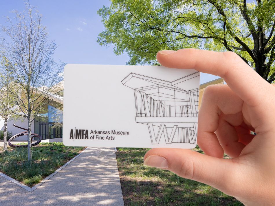 Close up photo of a hand holding an AMFA gift card in front of the Park Entrance to the Museum.