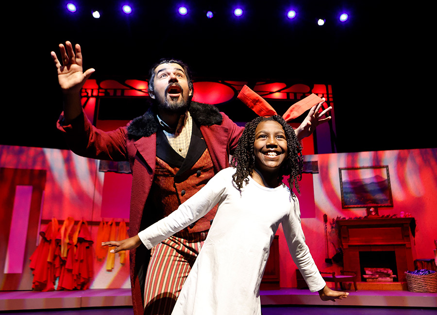 Photo of a man and a young girl performing a scene from Madelines Christmas on a stage.