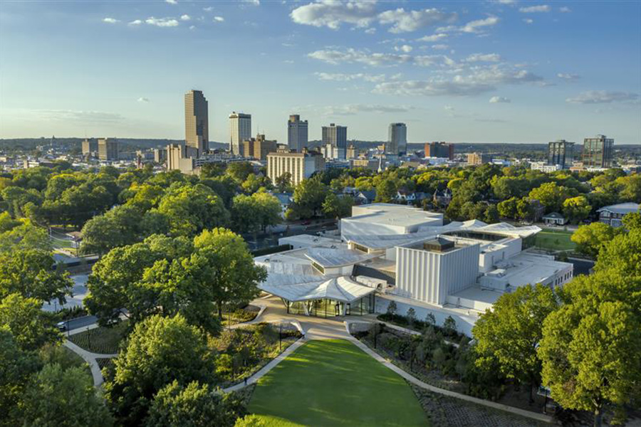 Aerial photo of the Arkansas Museum of Fine Arts with MacArthur Park in the foregrond and Downtown Little Rock in the background.
