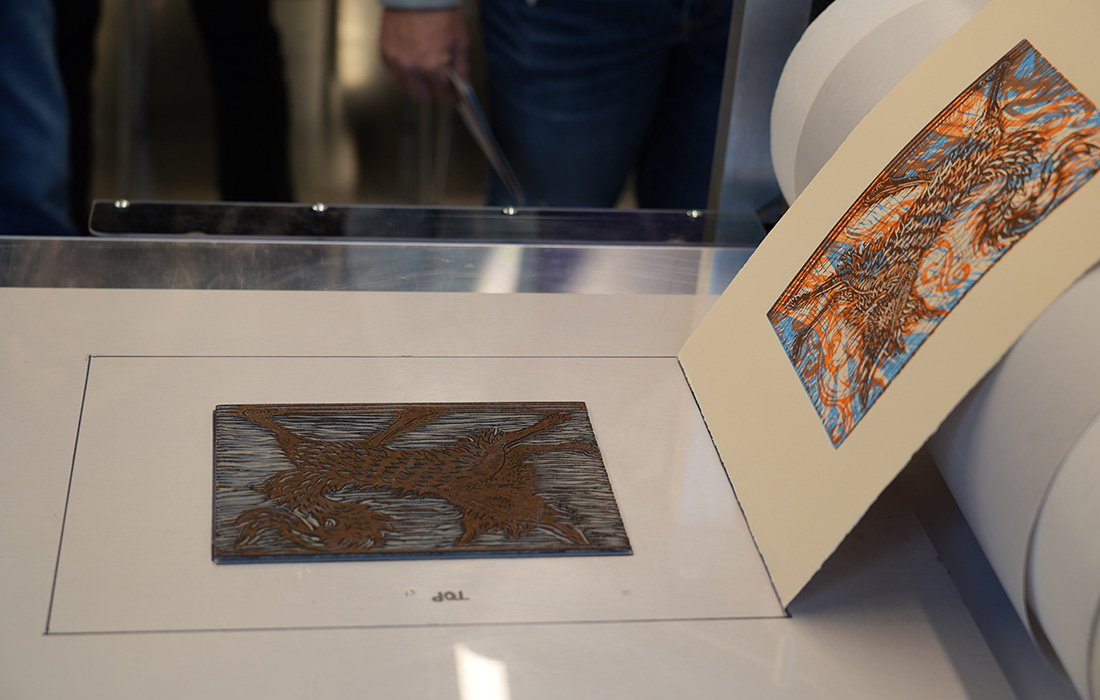 Photo of an abstract art print coming off a printing press.