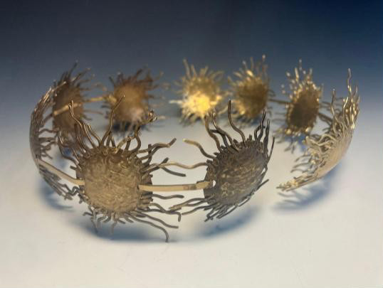 Photo of a handmade metal hairpiece in starburst shapes.