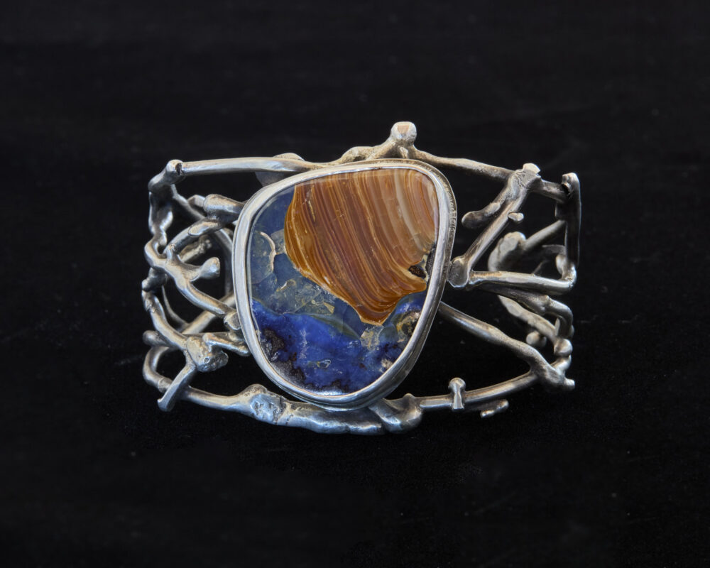 Photo of a handmade metal cuff with a large gemstone in the center.